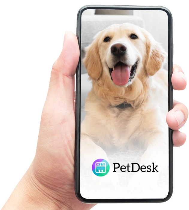 A hand holding a smartphone displaying a happy golden retriever with tongue out on the screen, with the PetDesk app logo shown below the image.